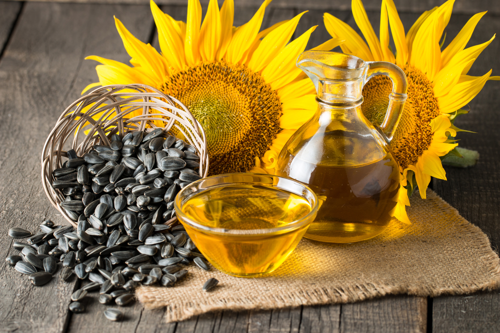 Sunflowers and seed oils displayed on a wooden table