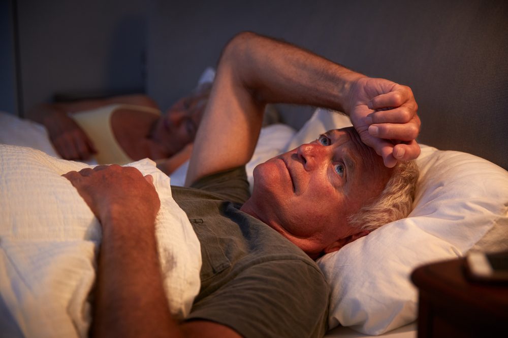 Worried Senior Man In Bed At Night Suffering With Insomnia